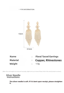 Macro view showing long gold flower tassel earrings with rhinestone details and measurements
