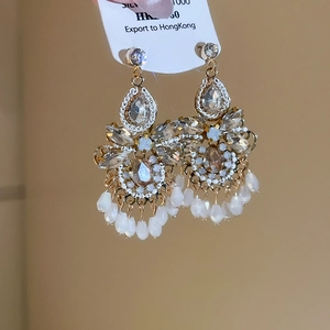 Detail von eleganten Kristall-Ohrhängern mit weißen Perlen und Silbersteckern im Fokus