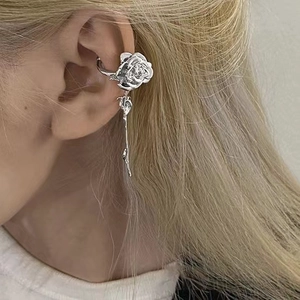 Detail view of silver rose ear cuff with long tassel earrings on a model side profile