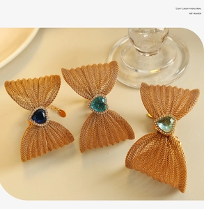 Detailed view of butterfly-shaped gold mesh jewelry with heart-shaped crystal centerpieces
