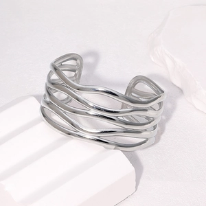 Detailed view of silver open cuff bracelet with wavy hollow layers on stone block