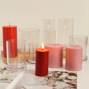 Detail view of cylindrical candle molds with finished red and pink decorative wax candles