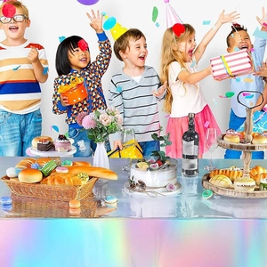 Detailed view of rainbow holographic tablecloth for birthday party with festive setting