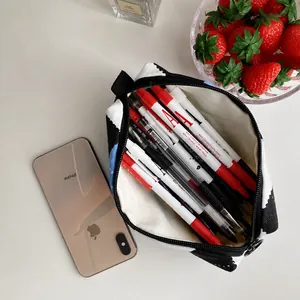 Internal view of the high-capacity checkered pencil case filled with various pens