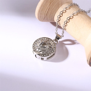 Close-up of a silver sun and moon projection necklace with sparkling crystal inlay