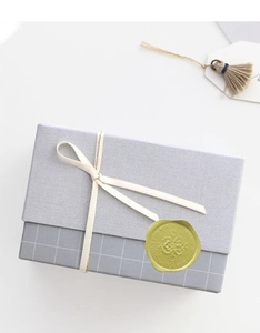 Detail of gold faux wax seal sticker on grey gift box with Especially For You text