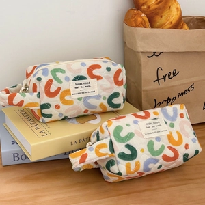 Quilted cosmetic bags with colorful patterns and handles in a cozy lifestyle setting