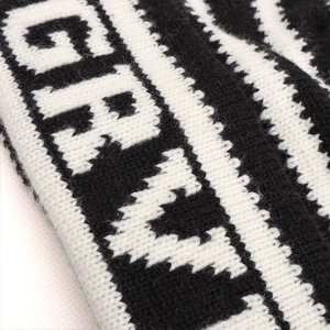 Détail du bonnet en maille rayée noir et blanc avec motif jacquard de lettres GRA