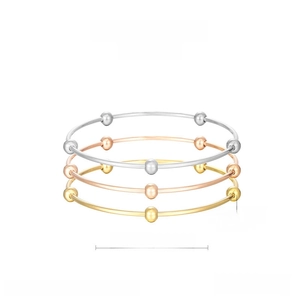 Three-color stacked stainless steel bangles in gold, silver, and rose gold finishes