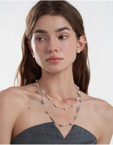 Detail of elegant double-layer necklace with white and grey pearls on a silver chain