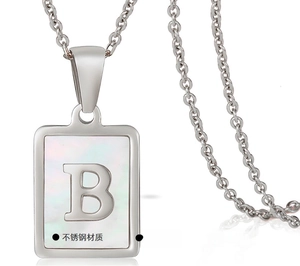 Detailed macro of polished stainless steel rectangle necklace with shell letter B inlay