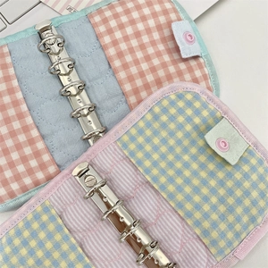 Close-up of quilted fabric six-ring binder featuring colorful plaid patchwork design