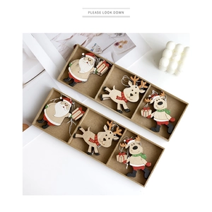 Drie houten kersthangers met kerstman en rendier ontwerpen in een geschenkdoos