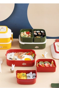 Detailed view of stackable cartoon rabbit bento boxes in yellow, green, and red plastic