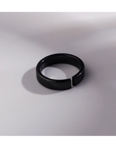 Detail view of a minimalist matte black open ring with a smooth industrial finish