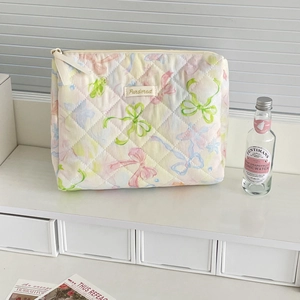 Close-up of quilted floral makeup bag with macaron patterns and diamond stitching detail