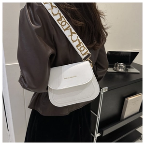 Chic white crossbody bag with stone texture, wide geometric strap and golden hardware