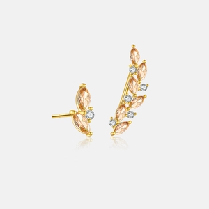 Detail of asymmetric gold branch earrings with amber marquise and white round zircon stones