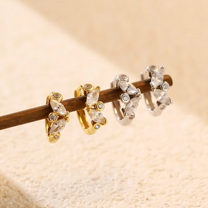 Detail view of gold and silver geometric hoop earrings with marquise and round crystals