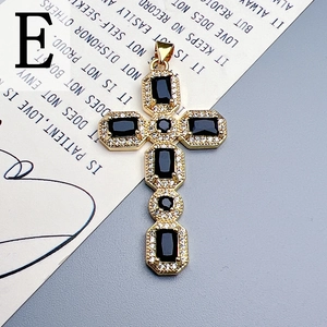 Detailed view of a gold cross pendant with black stones and clear diamonds on a poem card