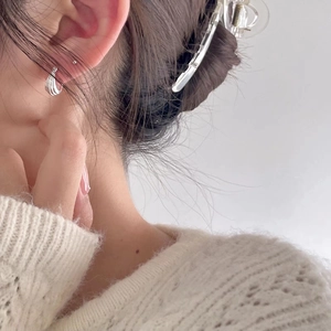 Minimalist 925 sterling silver U-shaped hoop earrings worn on ear with soft knit sweater