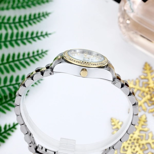 Close-up of a two-tone steel watch featuring a crystal bezel and a date display function