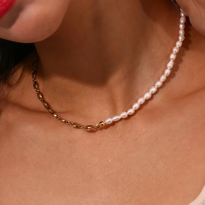 Detail of half-pearl and half-gold chain necklace on model showing elegant texture
