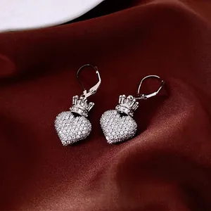 Boucles d'oreilles cœur couronne en zircone argenté sur tissu rouge foncé