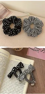 Detail of sequin hair scrunchies and bow elastics with heart charms in black and silver