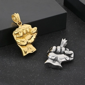 Detailed view of solid stainless steel fist pendants in gold and silver hip hop style