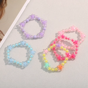 Detailed top view of colorful star acrylic bracelets on a textured grey background