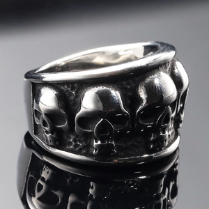 Dettaglio macro dell'anello teschio gotico con motivi a rilievo su acciaio vintage