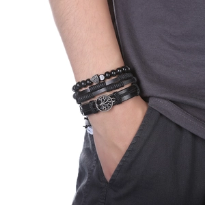 Gros plan sur un ensemble de bracelets en cuir multicouches avec breloques de bouclier