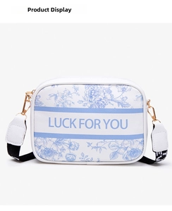 Detail of floral printed camera bag with woven strap and gold metal hardware hooks