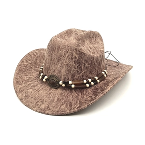 Close-up of distressed brown western cowboy hat with beaded band and metal buckle detail