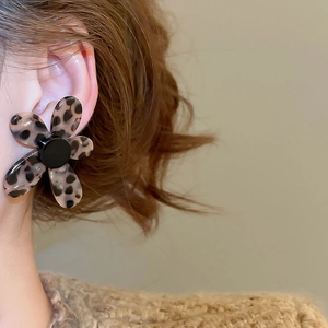 Detailed view of leopard print flower earrings with acetate petals and black center