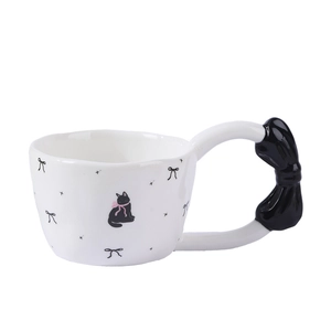 Ceramic mug with black bow handle featuring cute cat and butterfly patterns
