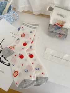 Close-up of cute cartoon cotton socks with red apple patterns and gray toe contrast