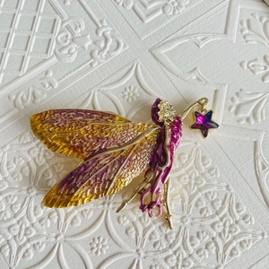 Detail of fairy brooch with gold purple gradient enamel wings and star rhinestone