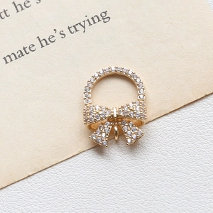 Macro detail of champagne gold bow pendant with micro-set zircons for jewelry making