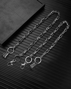 Detail of silver skull link chains with punk rock metal hooks on a black background