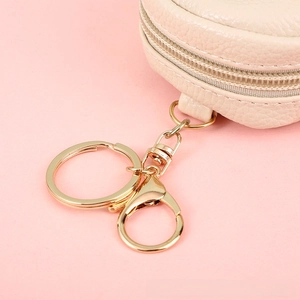Detail of off-white lychee texture coin purse with gold zipper and keychain hook