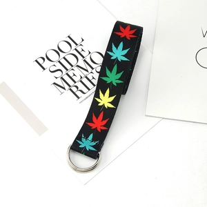 Detail of canvas belt featuring colorful leaf prints and metallic double D-ring buckle