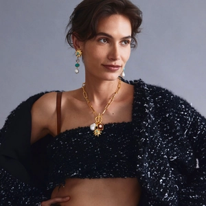 Close-up of golden multi-pendant necklace and earrings with pearls and star charms