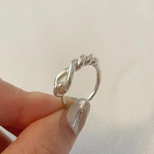 Detailed shot of an adjustable 925 sterling silver knot ring with a minimalist twisted design