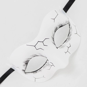 Detail of white Day of the Dead mask with black crackle paint and silk ribbons