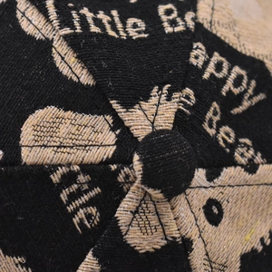 Macro detail of cartoon bear embroidery and premium fabric texture on baseball cap crown