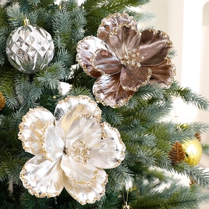 Sparkling champagne and bronze artificial Christmas flowers on pine tree branches