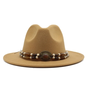 Detail of vintage camel wool fedora hat featuring ethnic beaded band and copper buckle