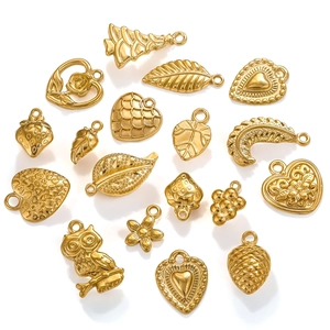 Macro view of assorted gold stainless steel charms including heart, leaf and strawberry